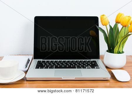 Laptop And Flower Pot On Wooden Table