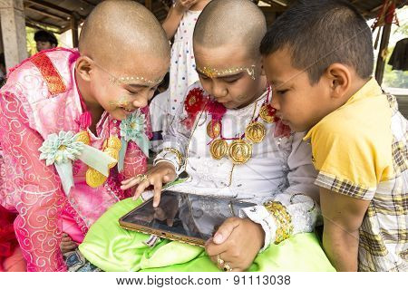 Mae Hong Son, Thailand - April 5, 2015: Unidentified Children Are Playing With Tablet Before The Cer