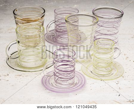 Two Sets Of Drinking Glasses With Yellow And Purple Streaks