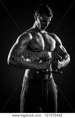 Mighty fitness man showing his gread body with dumbbells