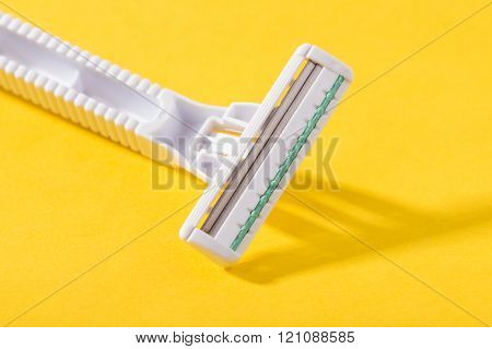 closeup new multiple blade razor on yellow background