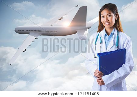 Asian doctor holding blue binder against mountain peak through the clouds