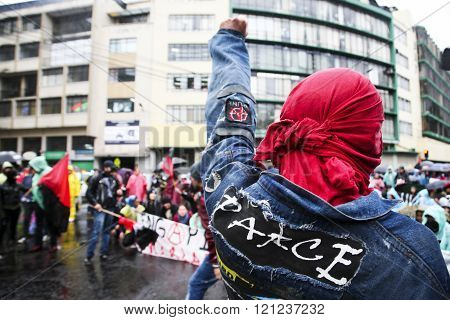 Quito, Ecuador - August 27, 2015: Man wearing denim jacket with peace patch on back raising fist tow