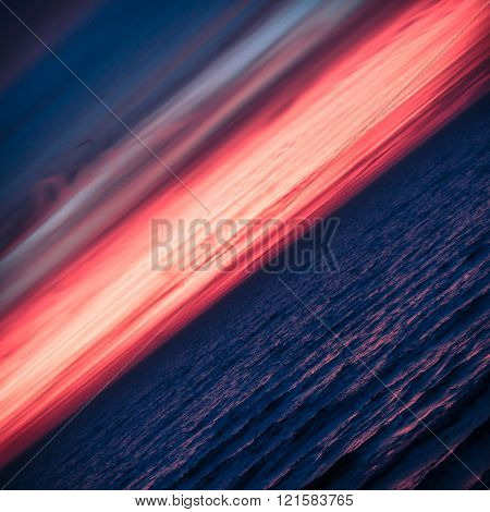 Beautiful Fiery Red Pink Sunset Horizon over Blue Ocean Sea Lake Water. Diagonal Square Layout Nature Background. After Dark Abstract Seascape with Copy Space.