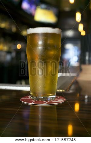 Cold draft beer sitting on a bar top