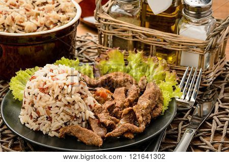 Stewed beef with boiled 3 colour mix rice on blck plate.
