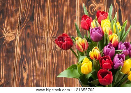 Assorted Tulips Bouquet. Burned Wooden Background. Copy Space