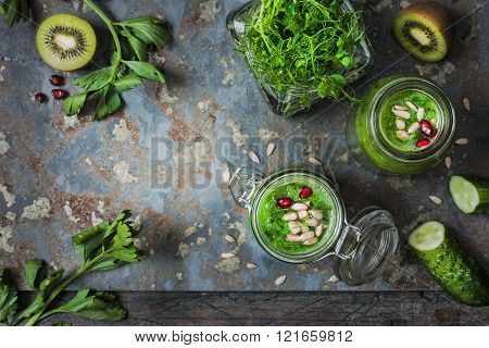 Ingredients for green vegan smoothie with pomegranate on the rustic table