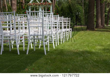 White wedding chairs on a green lawn, without decoration-2