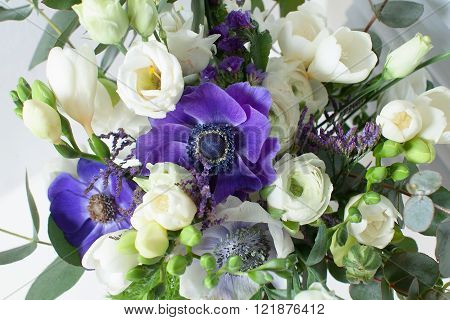 a bridal bouquet of roses and ornamental poppies in the background.