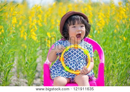 Cute Asian Girl In Yellow Sunhemp Flower Field