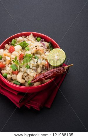 Indian breakfast or snack food upma or upama, sweet and salty food, served in a red ceramic bowl
