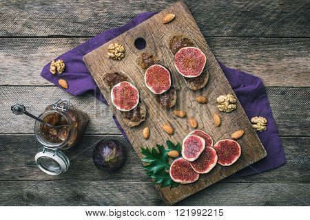Sliced Figs, Nuts And Bread With Jam On Wooden Choppingboard