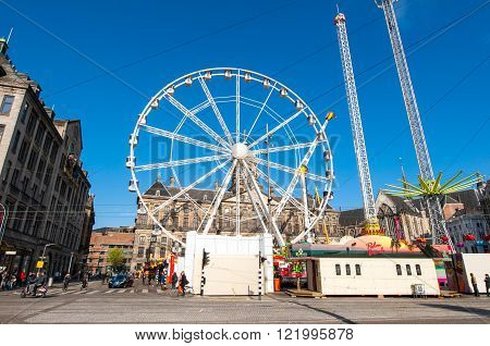 AMSTERDAMNETHERLANDS-APRIL 27, 2015: Ferris wheel on Dam Square on the eve of King's Day on April 27 2015 in Amsterdam. King's Day is the largest open-air festivity in Amsterdam.