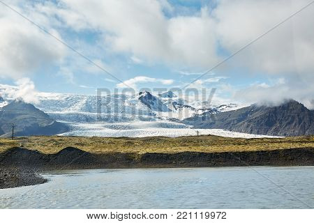 Travel to Iceland. bright sunny mountain landscape. Vatna volcano covered with snow and ice on tne background.