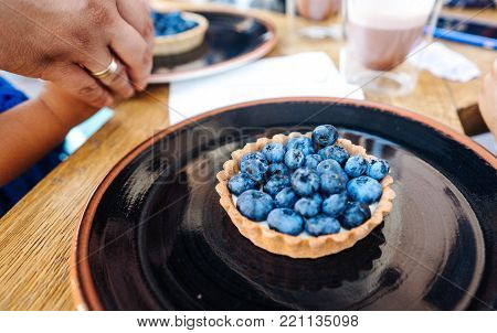Dessert with blueberries in an edible basket on the table