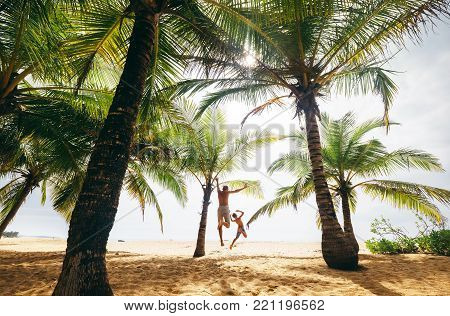 Madly jumping futher and son on the lonely island beach