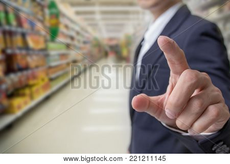 Choice of buying for health concept : Businessman finger touching with suppermarket blur background.