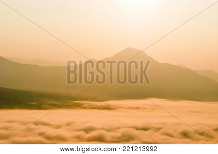 Early morning foggy sunrise on top of mountain soft focus.