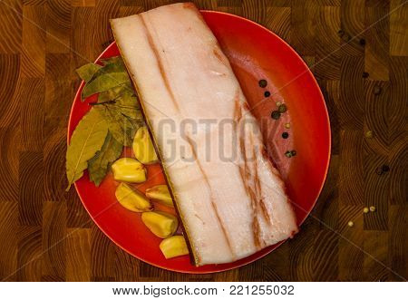 Cooking national Ukrainian dish - a big piece of raw of lard with spices before salting