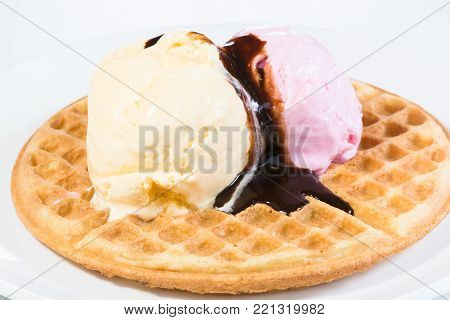 Vanilla and strawberry ice cream on a waffle and glazed with belgian chocolate sauce