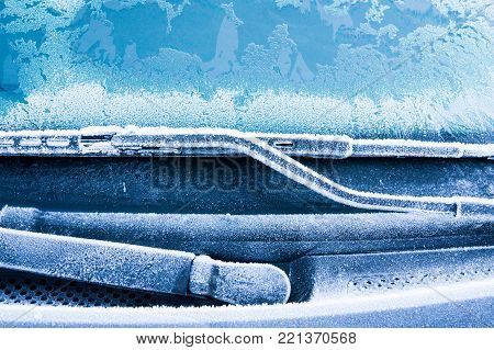 Iceflowers, frozen.The ice-cold frost forms ice crystals in beautiful unique patterns on the window, Hood and wiper on the Car