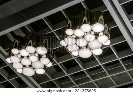 Close image of two modern metal chandeliers on ceiling