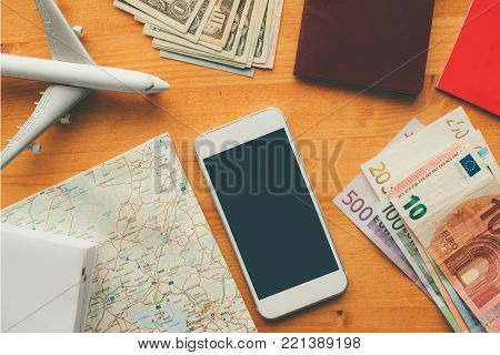 Overhead view of vacation travel concept with smartphone blank screen as mock up copy space for hotel reservation and booking mobile app or airplane ticket purchase application.