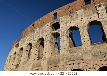 Exterior of the Colosseum against a bright blue sky