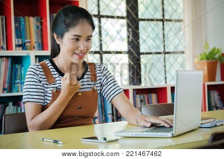 Young successful woman sitting at her desk in the library.