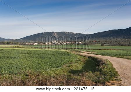 Small hamlet in an agricultural landscape in La Mancha, Ciudad Real Province, Spain. In the background can be seen the Toledo Mountains