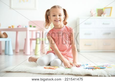 Cute little girl playing with pazzles at home