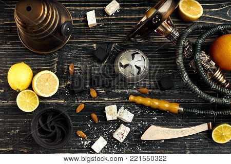Arabic hookah with a tobacco flavor of a mixture of lemon. Top view of a dark wooden background. Still life. Copy space. Flat lay