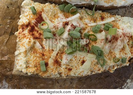 A slice of bread with garlic spread and green and white onion