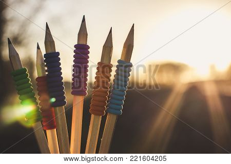Different pencils against of the bright sunlight background. Warm spring background.