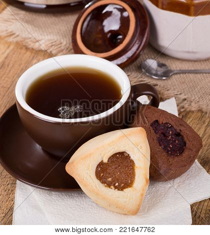 Apricot and raspberry filled hamantash cookies and cup of coffee