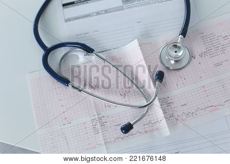docter workplace with a stethoscope Cardiogram chart with medical table closeup, for heart record.