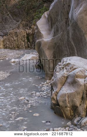 Canyon Saklikent, smooth rocks of canyon walls, with a river covered with silvery reflections of the sun