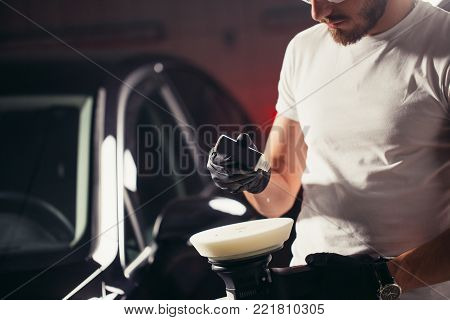 auto mechanic worker prepare for polishing car by power buffer machine