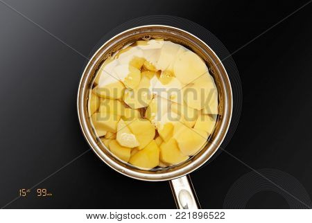 pan on the induction surface in which potatoes is cooked