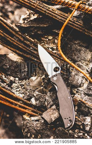 Knife for city carrying. Knife with a hole in the blade. Vertical shot.