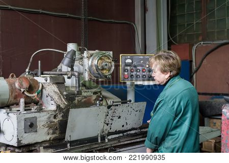 Lipetsk, Russia - June 15, 2017: Lipetsk Machine Tool Plant. A woman works on an internal grinding machine. Stage of metal finishing of parts.
