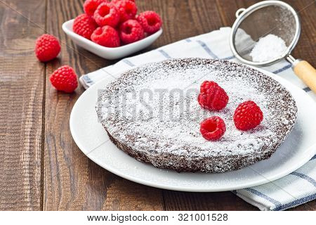 Chocolate Sticky Brownie Cake, Swedish Dessert Kladdkaka, On The Plate, Garnished With Icing Sugar A
