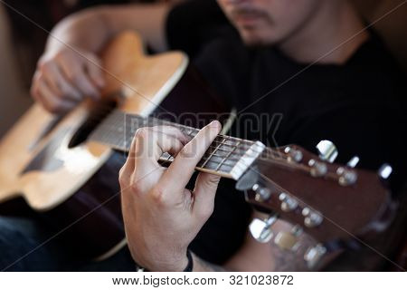 Close-up Male Hands Plaing Barre On Acoustic Guitar In Interiour