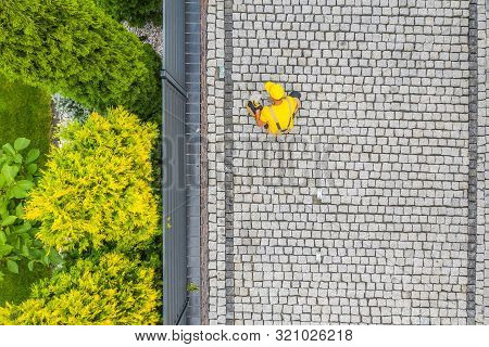Residential Bricks Driveway Building. Caucasian Construction Worker Finishing Granite Decorative Bri