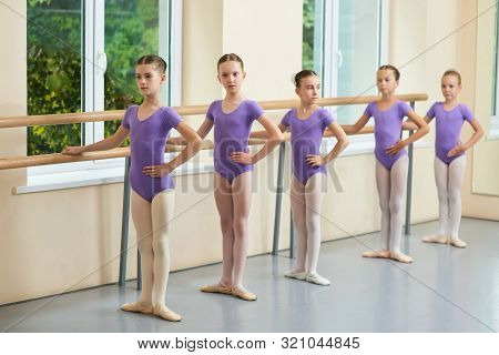 Five Young Ballerinas Standing In Pose. Ballet Dance Lesson, Kids In Similar Suits. Ballet Foot Posi
