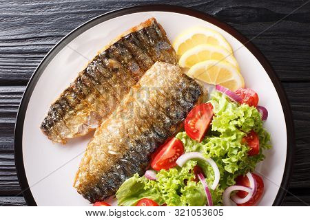 Portion Of Grilled Mackerel Fillet With Lemon And Fresh Vegetable Salad Close-up On A Plate. Horizon
