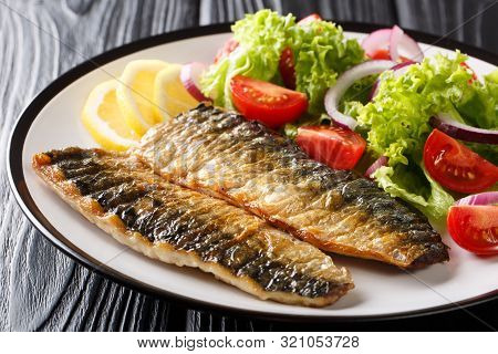 Diet Healthy Food Grilled Mackerel Fillet With Lemon And Fresh Vegetable Salad Close-up On A Plate.