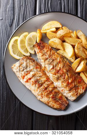 Spicy Tasty Grilled Mackerel Filet With Potato Wedges And Lemon Close-up On A Plate. Vertical Top Vi