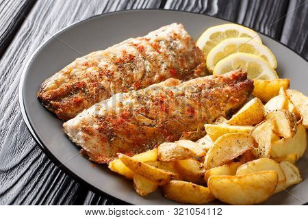 Grilled Mackerel Filet Served With Fried Potatoes And Lemon Slices Closeup On A Plate. Horizontal